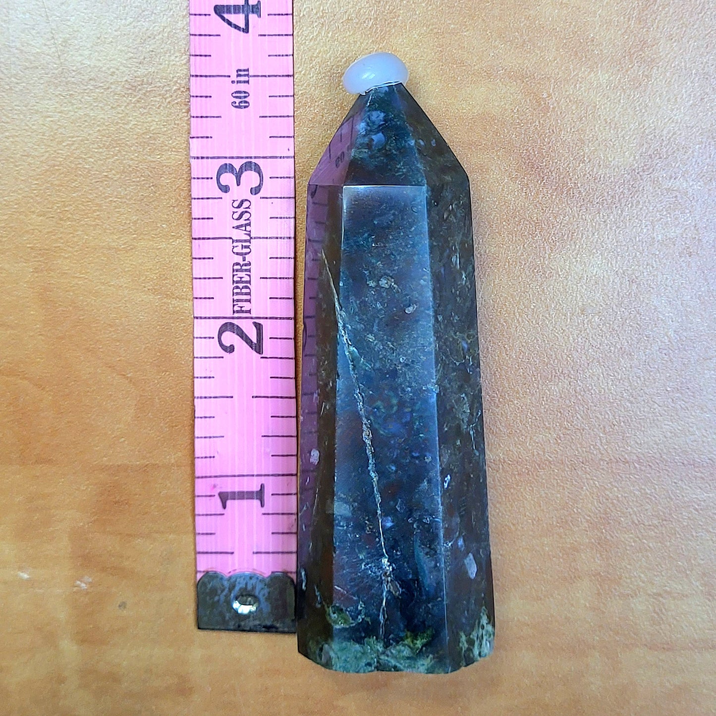 Ocean jasper tower with unique patterns displayed alongside a ruler for size reference