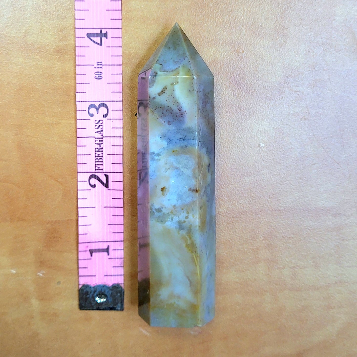Ocean jasper tower in purple and brown hues with a ruler for size reference