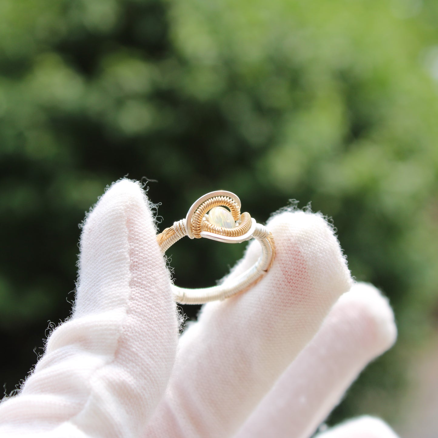 Elegant Opal Sterling ring displayed on a gloved hand, showcasing its unique design and color