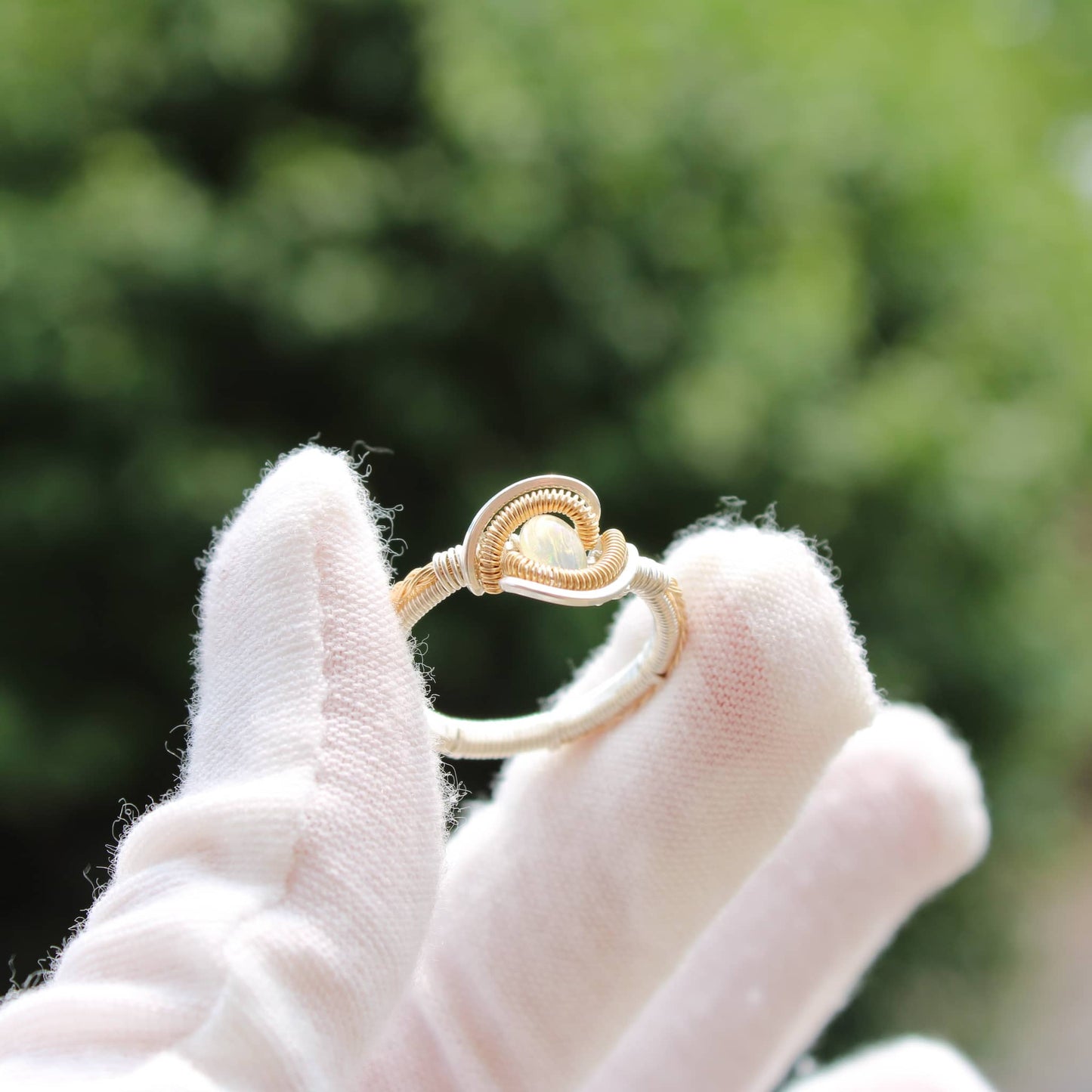 Elegant Opal Sterling ring displayed on a gloved hand, showcasing its unique design and color