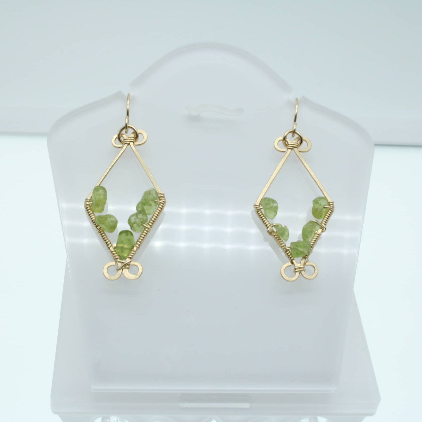 Unique peridot chip earrings featuring delicate green gemstones set in gold wire design
