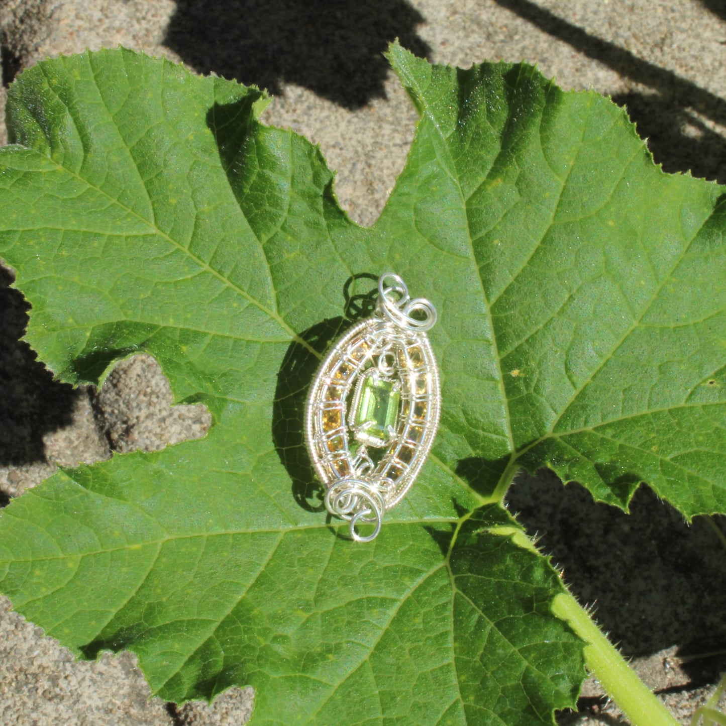 Peridot Sterling Silver yellow tourmaline gemstone pendant on a green leaf