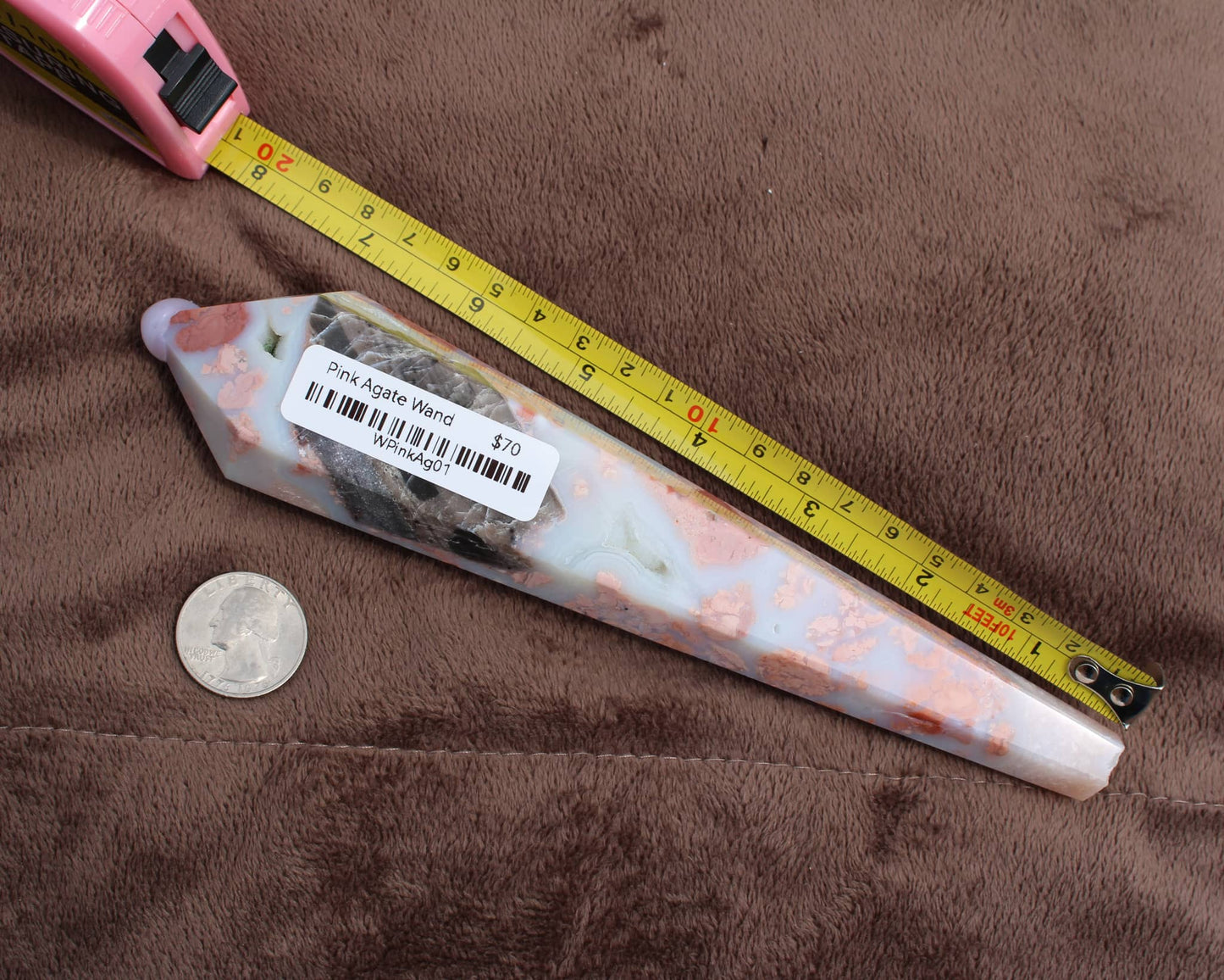 Pink Agate Wand crystal from Different Branches LLC with measuring tape and quarter for scale