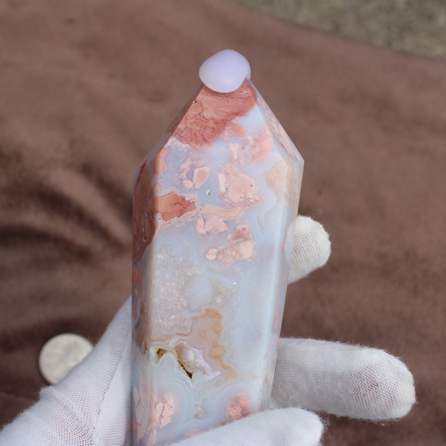 Pink Agate Wand crystal with unique pink and white patterns held by a gloved hand