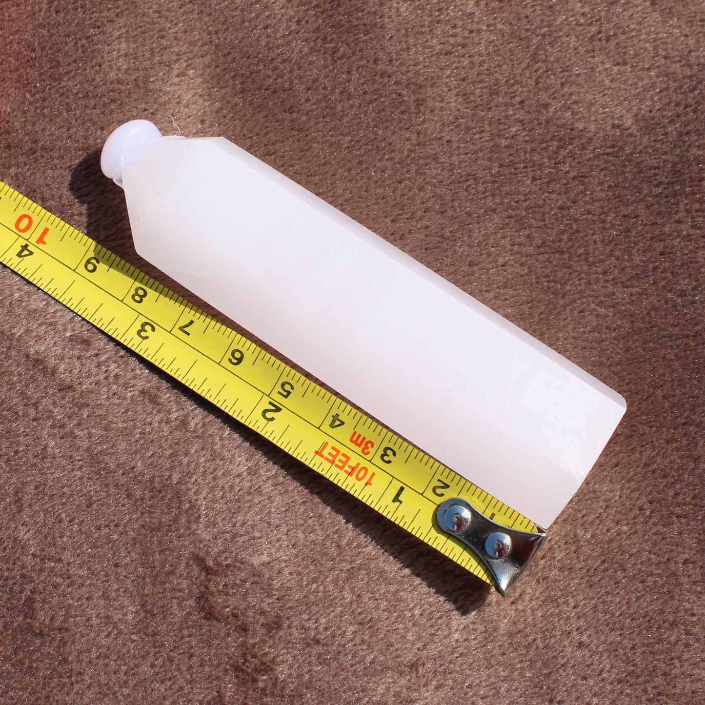 Pink Calcite Tower crystal measuring approximately 7 inches from Different Branches LLC on a brown surface