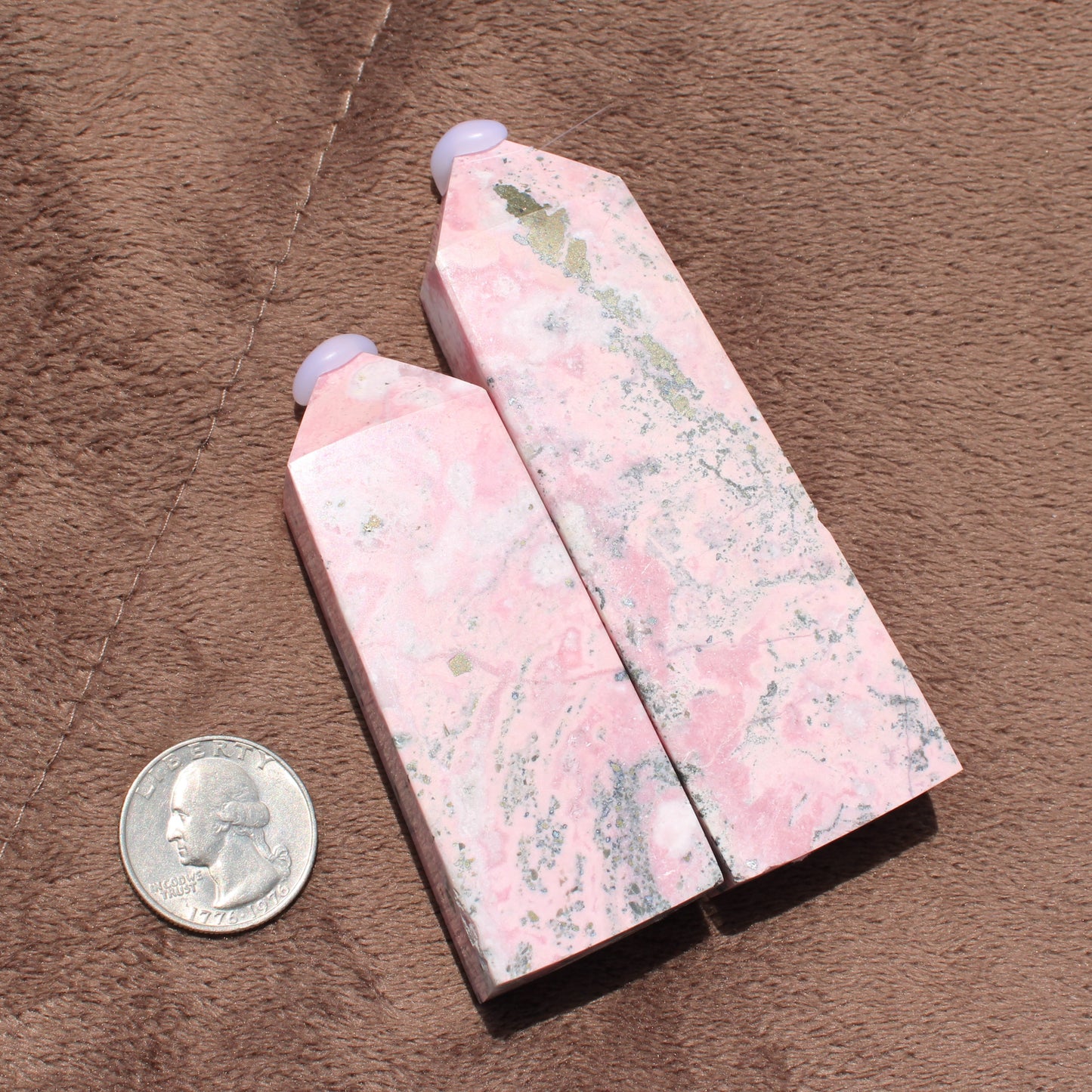 Two polished Pink Opal Tower crystals with natural white and gray patterns displayed beside a quarter for size reference