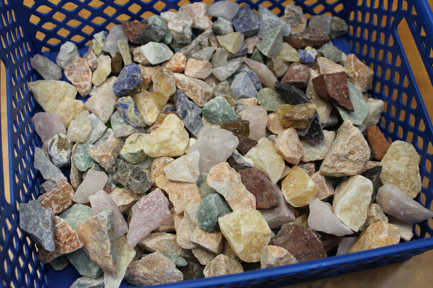 Basket of multicolored rough crystals and tumbled stones for a large gem mining mystery bag