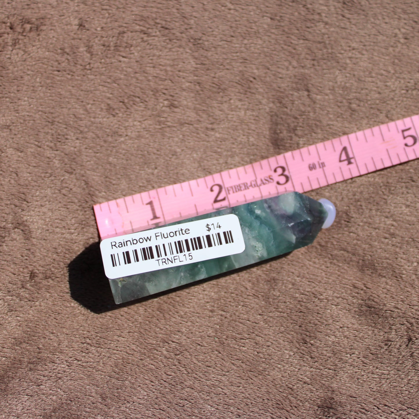 Rainbow Fluorite tower with natural green and purple hues on a soft background