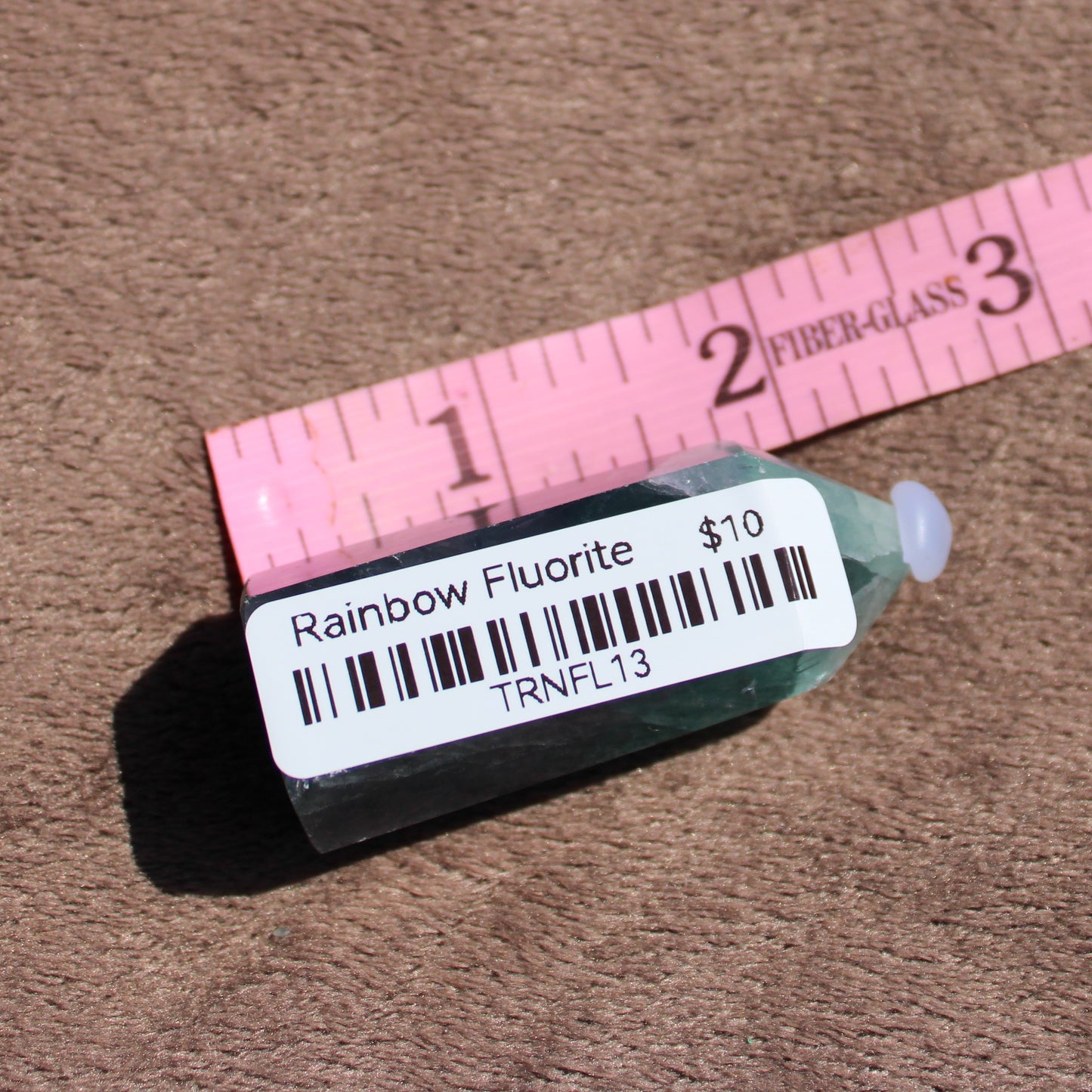 Rainbow Fluorite tower with a smooth, polished finish displayed next to a measuring tape