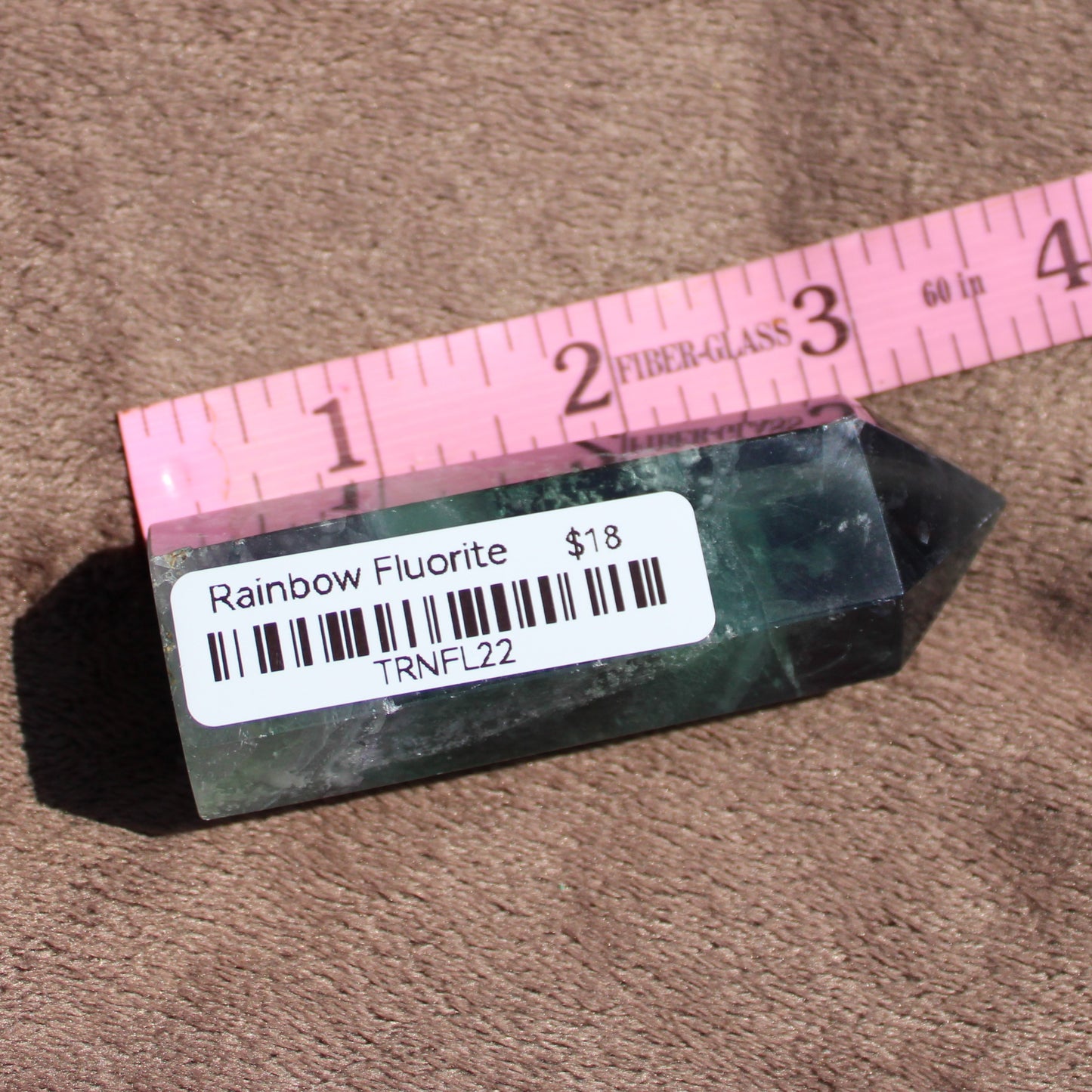 Rainbow Fluorite tower in various colors with a measuring ruler for size reference