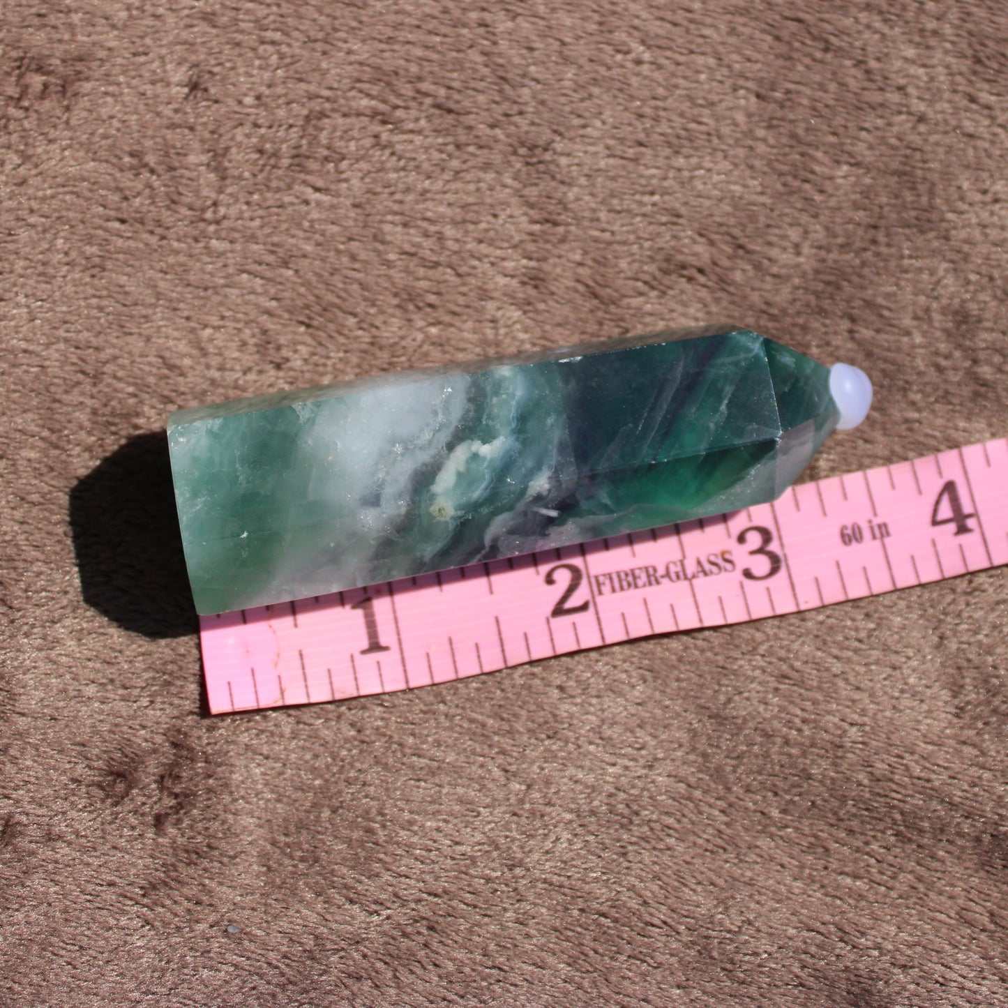 Rainbow Fluorite tower with green and purple hues on a soft background, ideal for decor