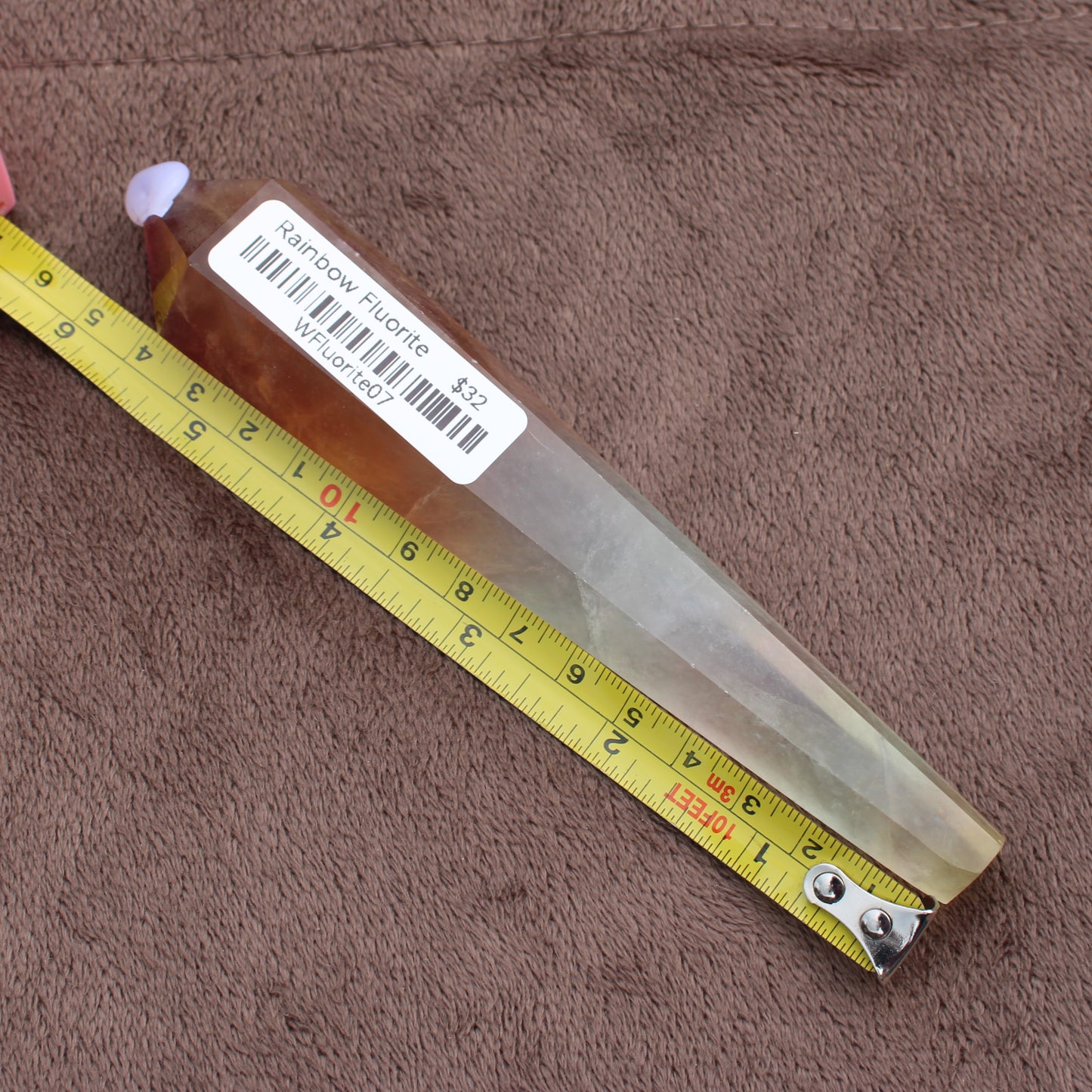 Rainbow Fluorite Wand crystal from Different Branches LLC shown with measuring tape for size