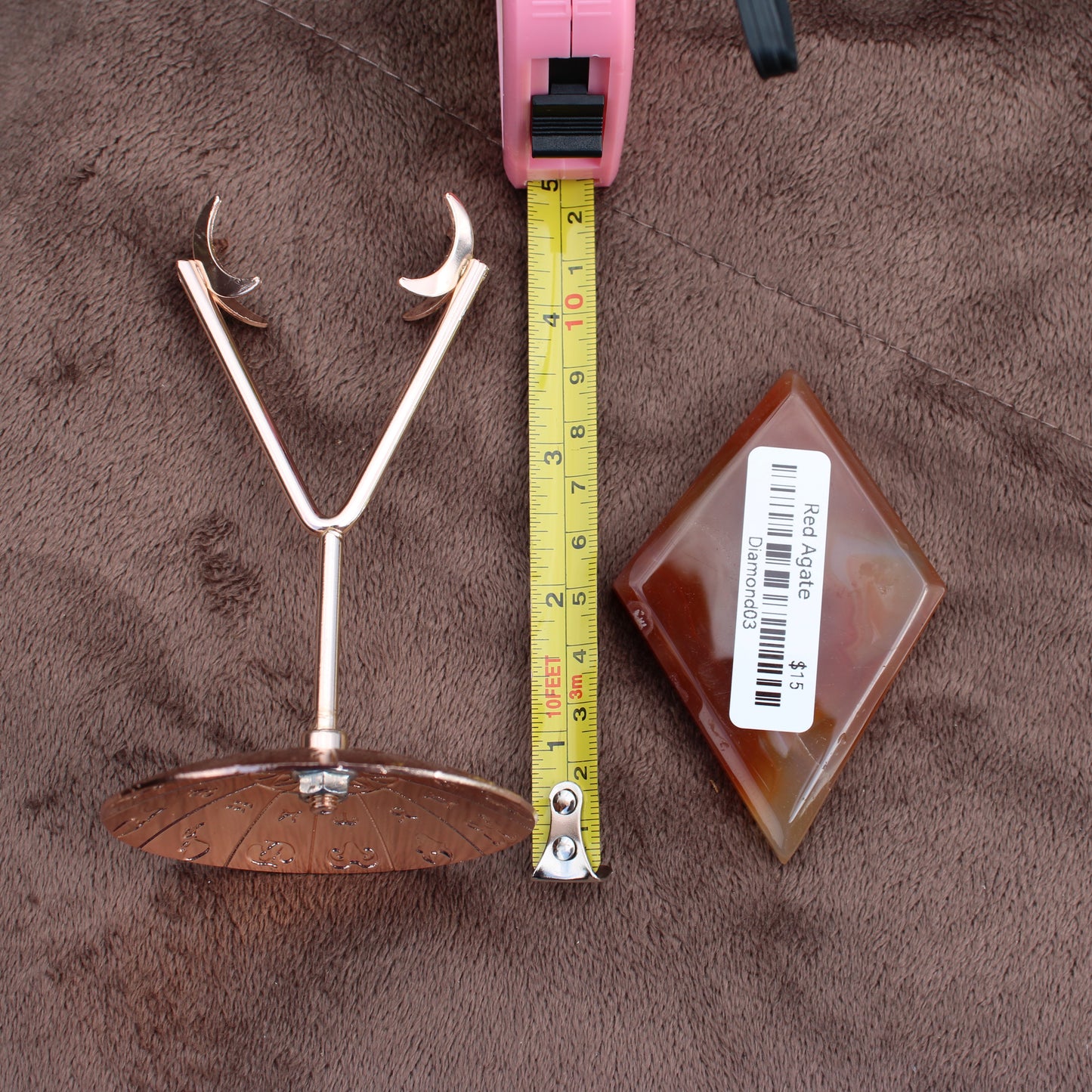 Red Agate Diamond crystal from Different Branches LLC displayed next to a tape measure and metal stand