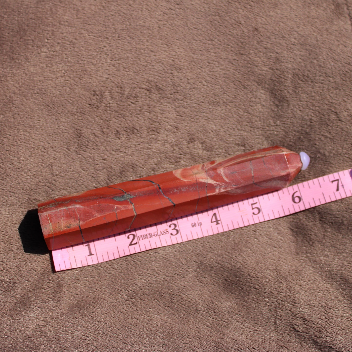 Red jasper tower with natural patterns, measuring approximately six inches in length