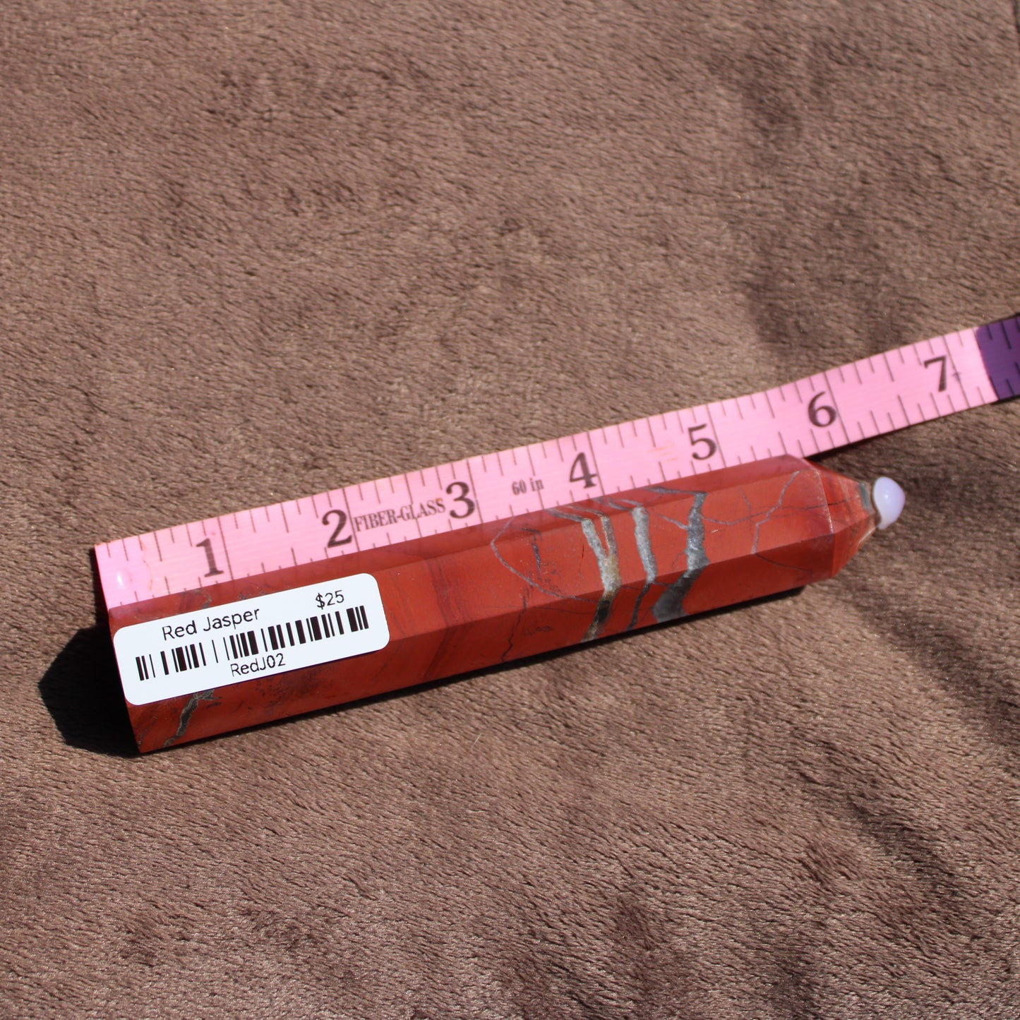Red jasper tower with smooth surface and natural patterns for decorative or healing purposes