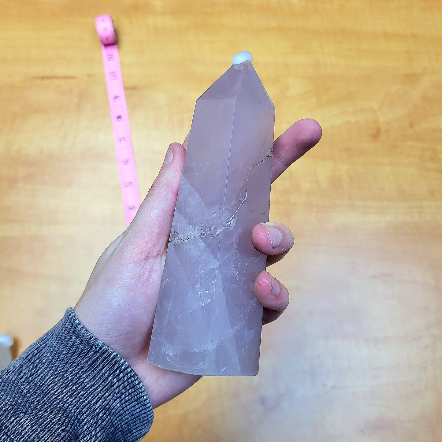 Hand holding a Rose Quartz Statement Tower with a smooth polished surface and unique facets