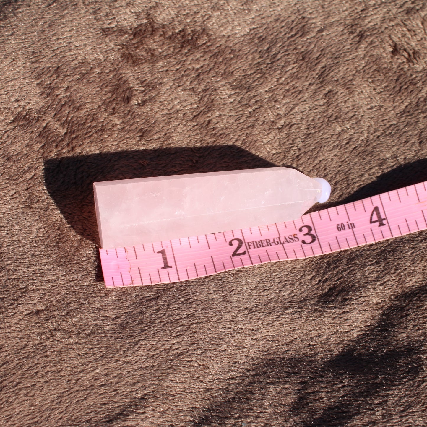 Natural Rose Quartz tower with smooth edges and a light pink hue for healing and decoration
