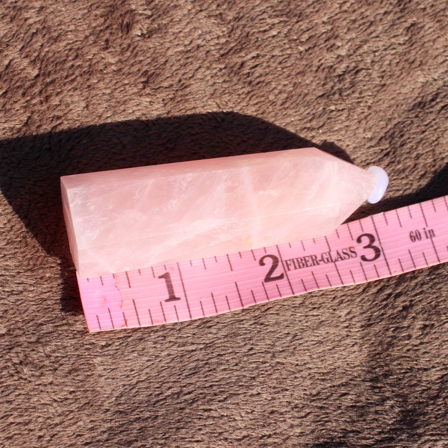 Rose Quartz tower from Different Branches LLC, showcasing a smooth pink surface and tapered design