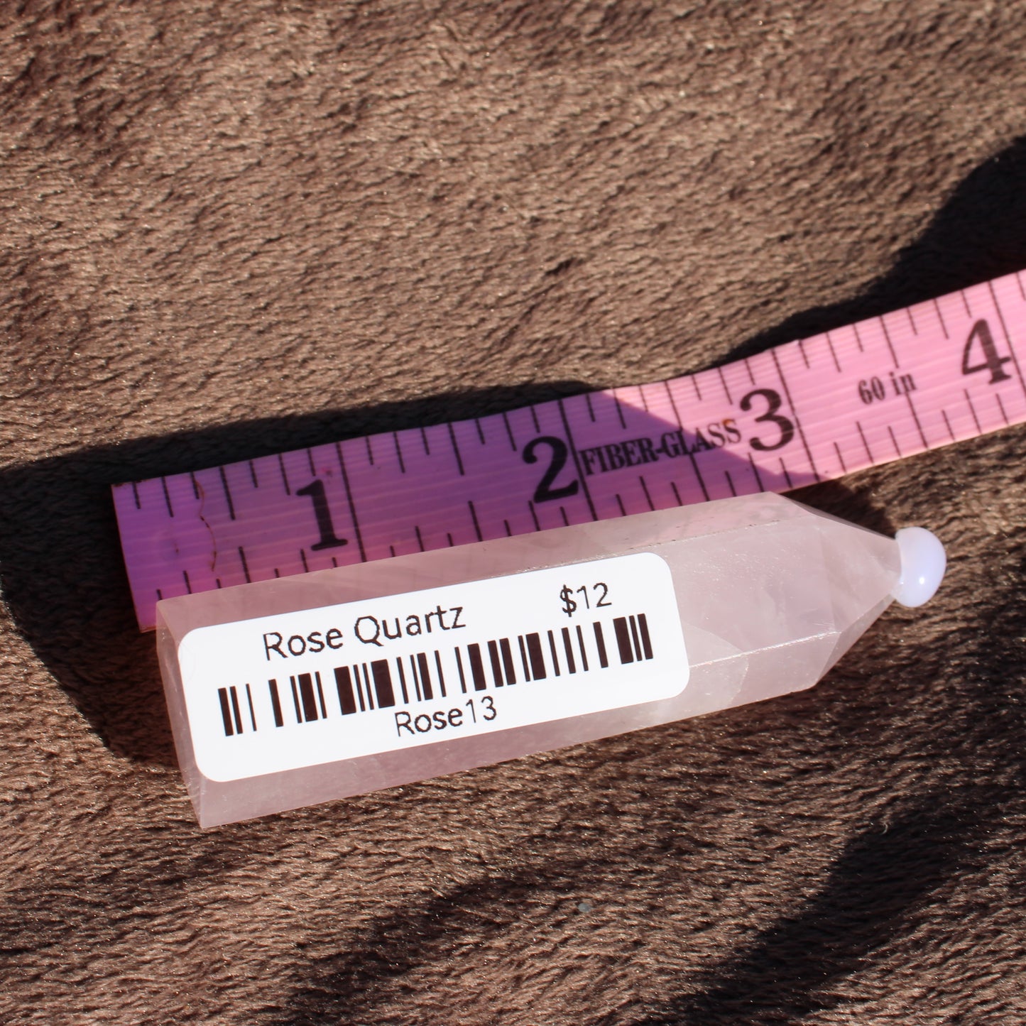 Rose Quartz tower with smooth finish and measuring scale for size reference
