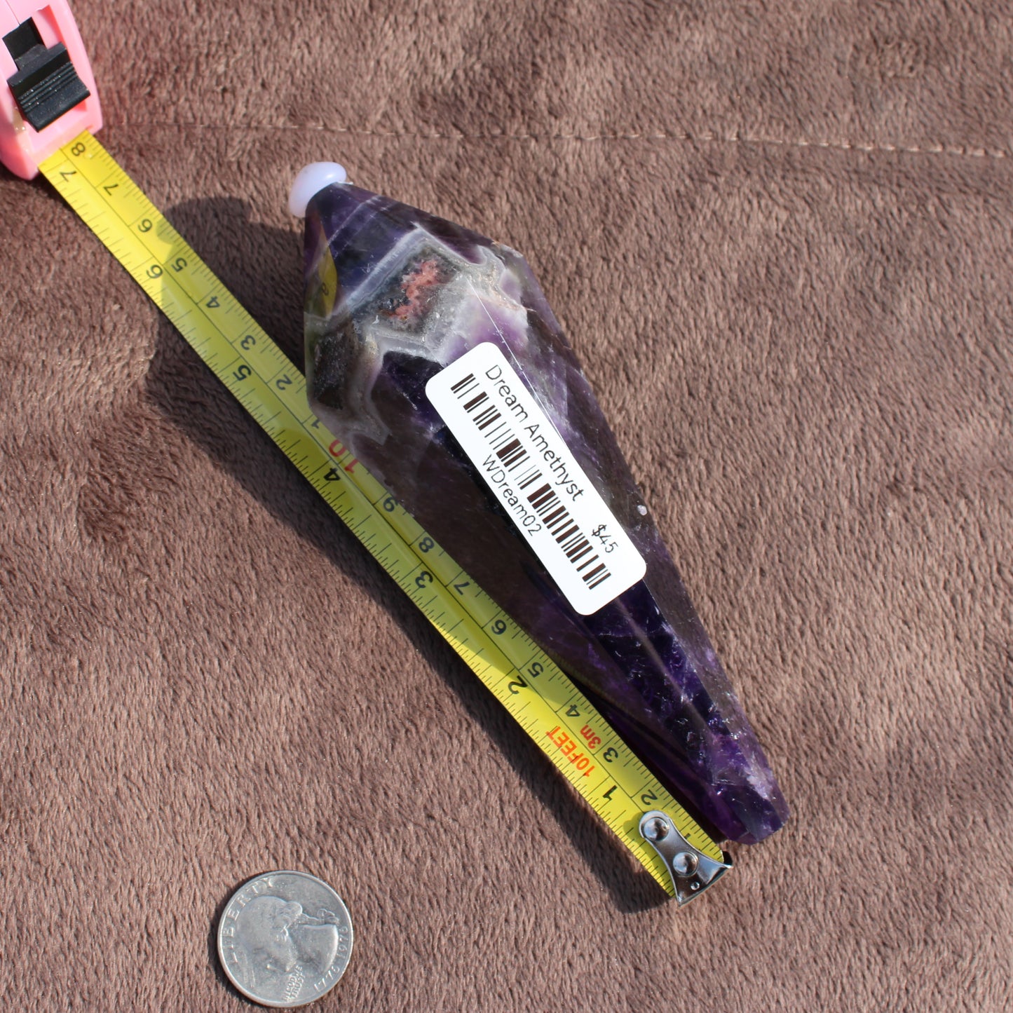 Thick Amethyst Wand crystal from Different Branches LLC next to measuring tape and quarter for size reference