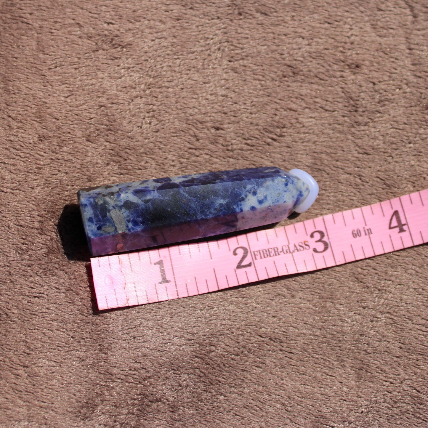 Sodalite tower crystal featuring rich blue hues and natural patterns with measuring tape for size reference