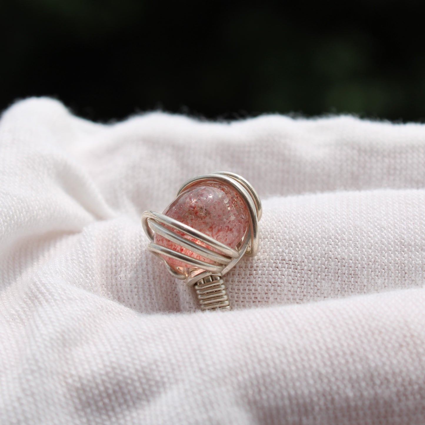 Strawberry quartz ring wrapped in silver wire, showcasing its unique color and design.