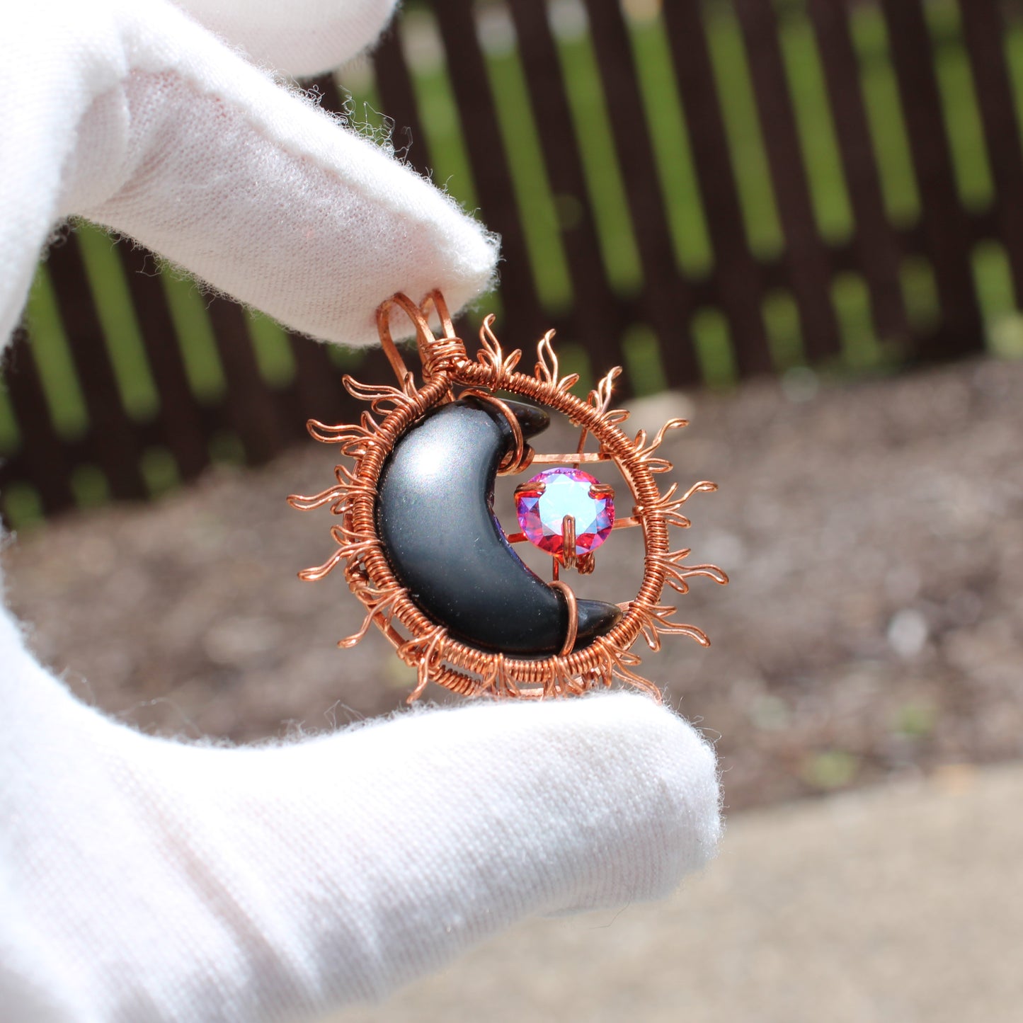 Sun and moon copper collection pendant featuring a black crescent moon and a colorful gemstone