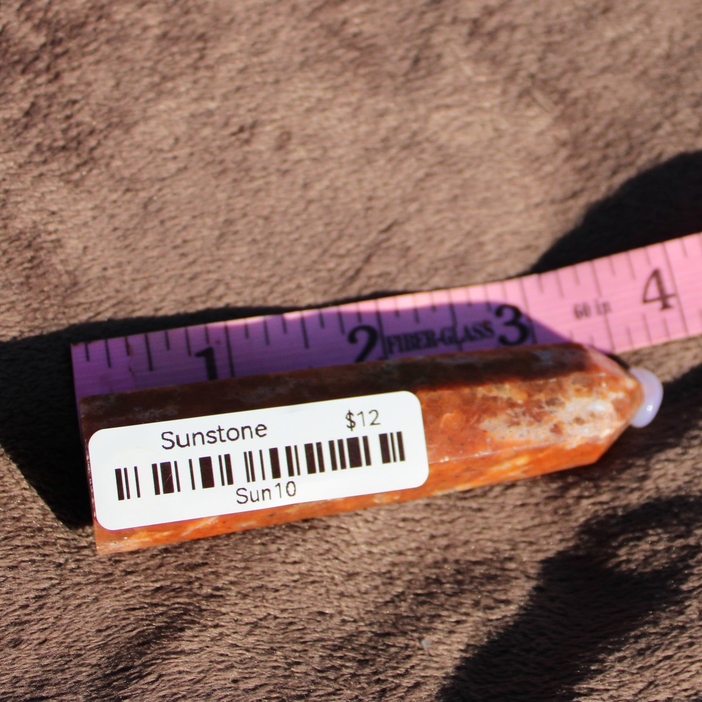 Sunstone tower from Different Branches LLC displayed with a measuring tape for size reference
