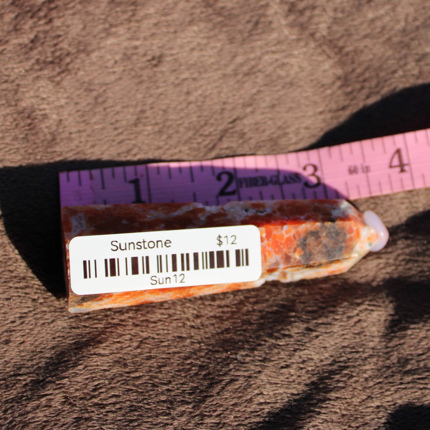 Sunstone tower crystal with vibrant orange hues and natural patterns, perfect for energy healing