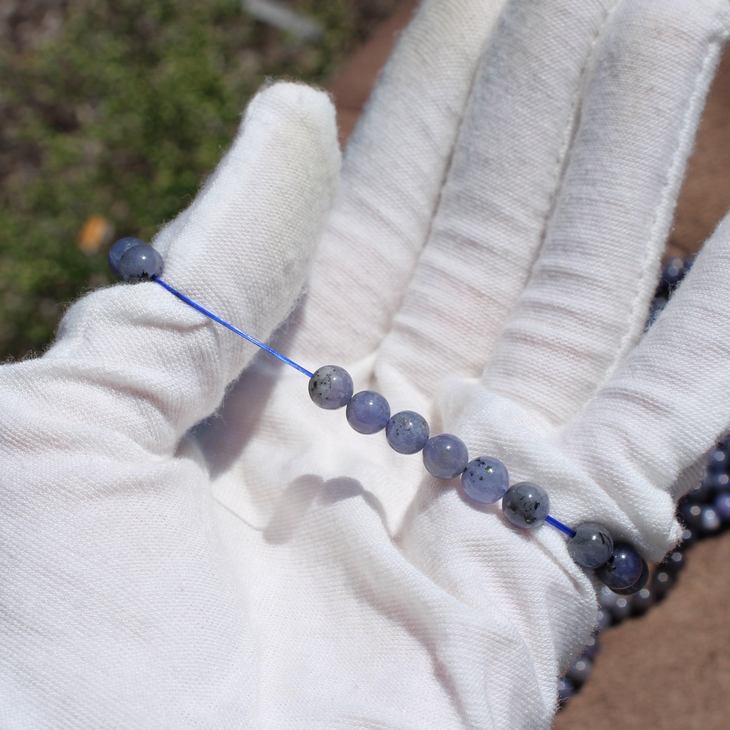 Tanzanite Bracelet displayed in a hand with a soft white glove, showcasing the beautiful gemstones