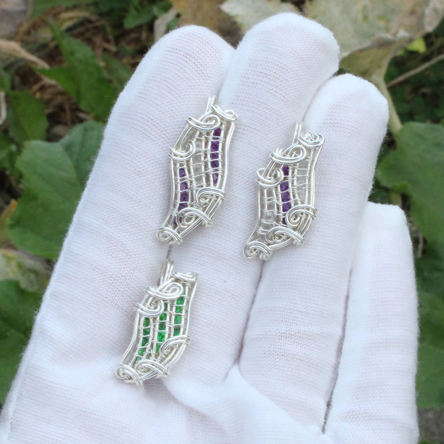 Elegant Tsavorite Sterling Silver Pendant on a white glove among greenery