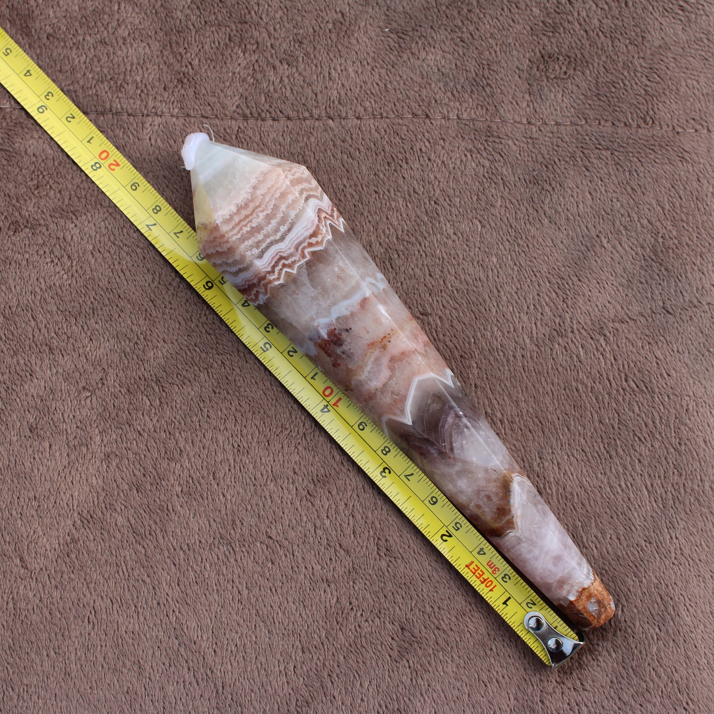 Crazy Lace Agate Wand crystal measuring approximately 9 inches on brown fabric background