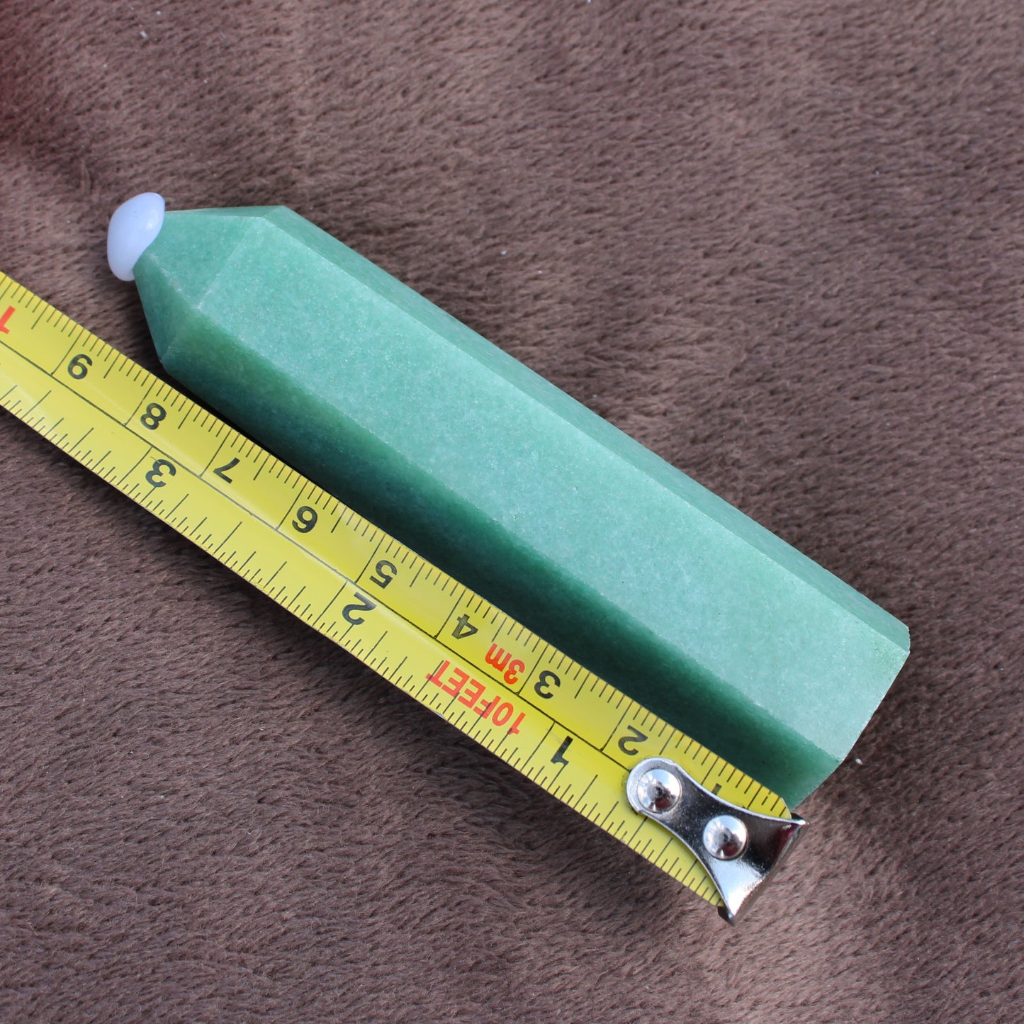 Green Aventurine Tower crystal with pointed tip next to tape measure showing size