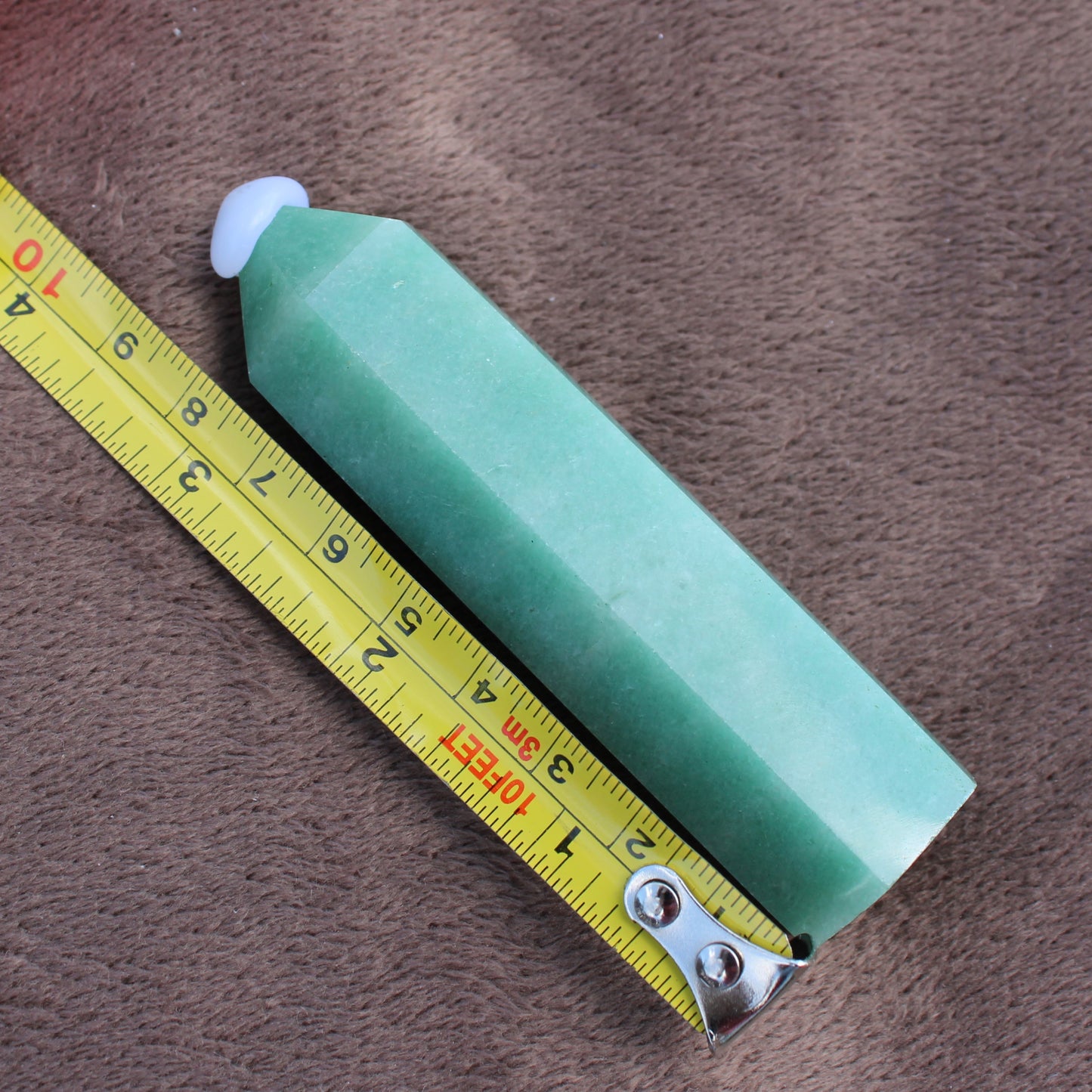 Green Aventurine Tower crystal measuring approximately 5 inches on a brown background