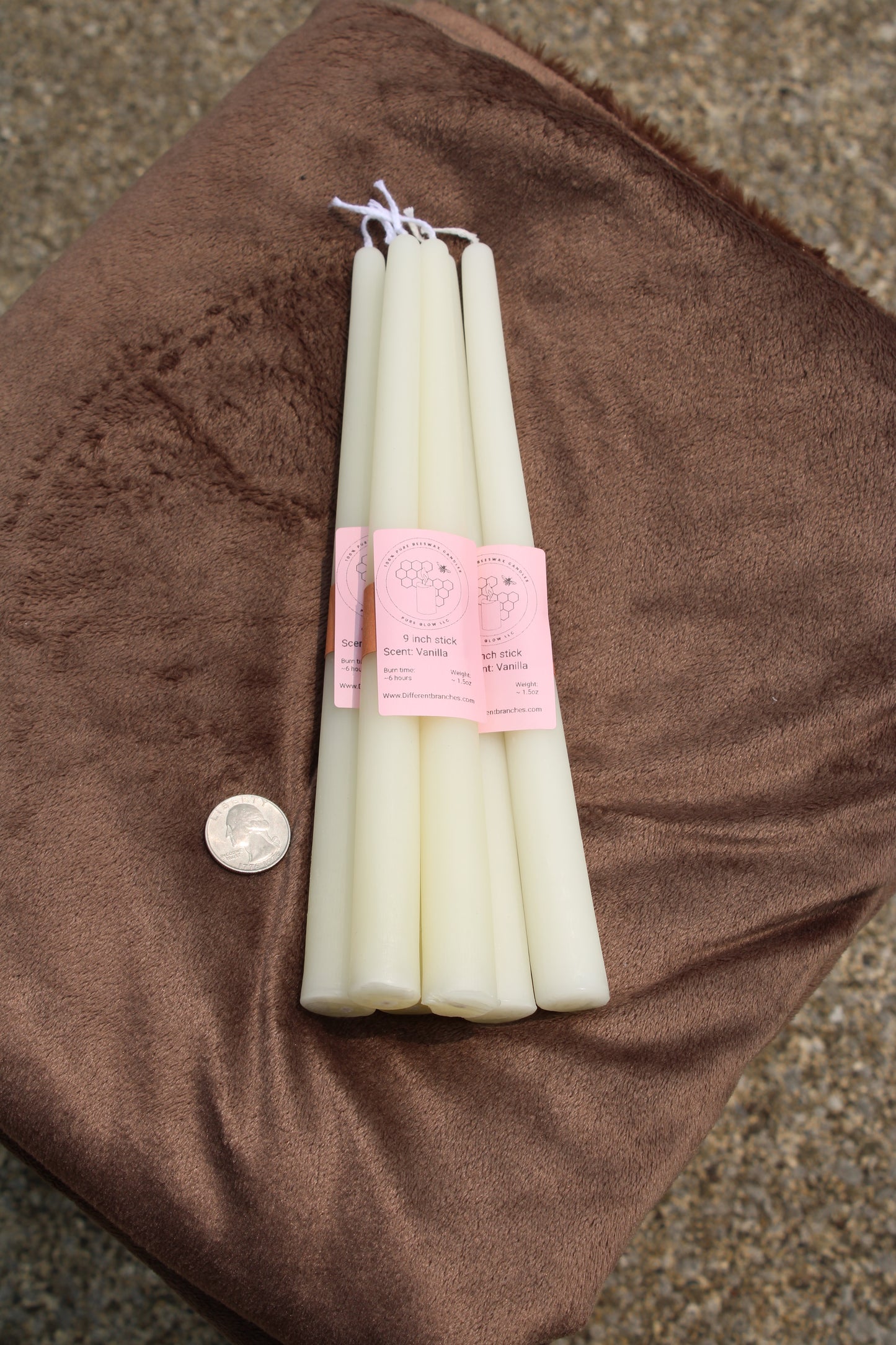 Set of white taper candlesticks by Different Branches LLC displayed on a soft surface with a coin for scale