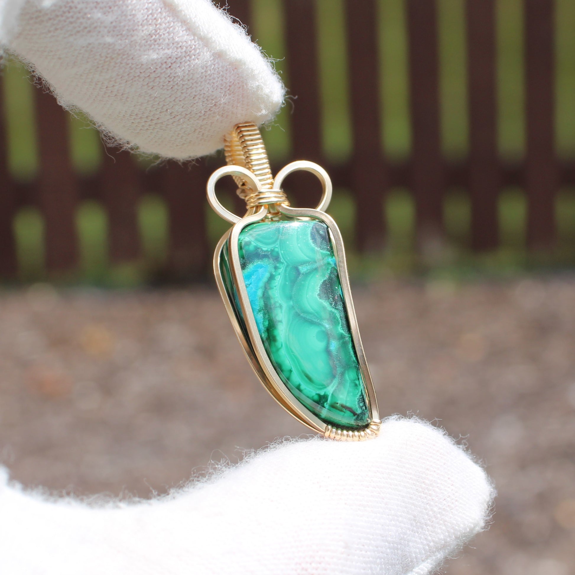 14k Gold Filled Chrysocolla Malachite pendant jewelry piece held by white glove