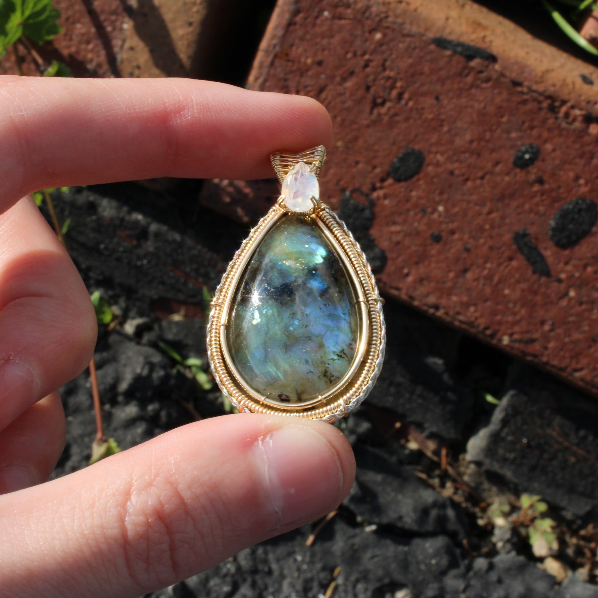 Rainbow Moonstone & Labradorite 14k Gold fill pendant showcased against a natural background