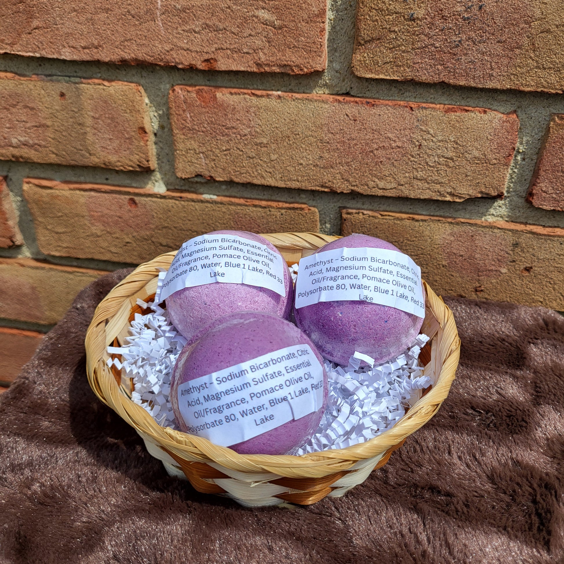 Amethyst Bath Bombs in a woven basket with decorative filling for a relaxing bath experience