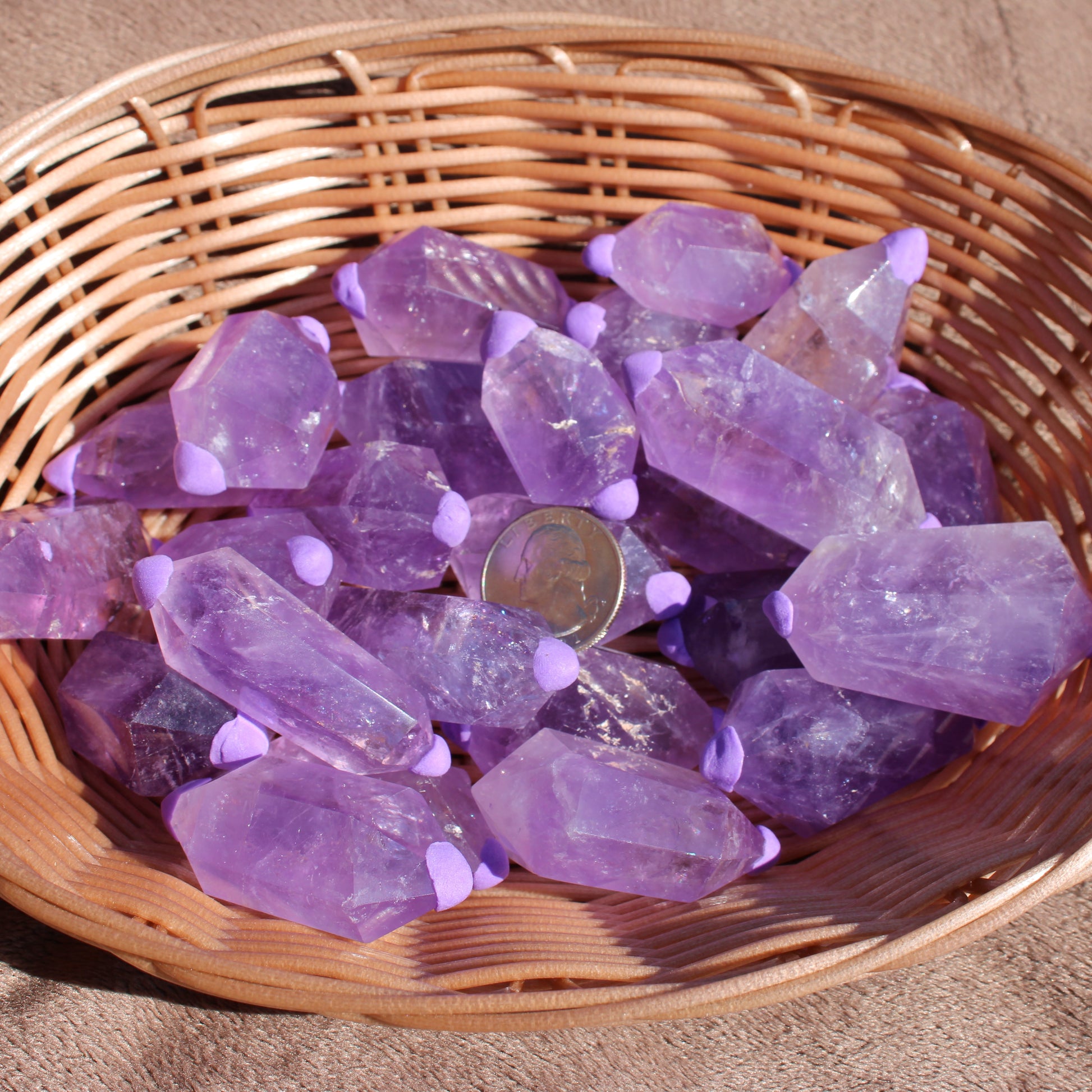 Amethyst double points in a woven basket showcasing their vibrant purple color and unique shapes