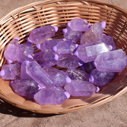 Amethyst double points in a wicker basket showcasing their beautiful purple color and unique shapes