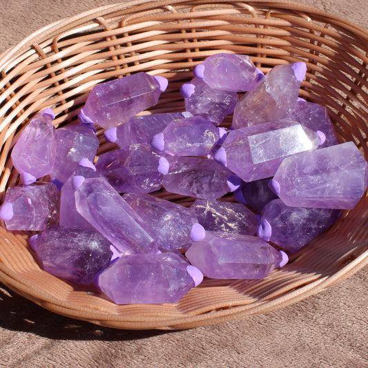 Amethyst double points in a wicker basket showcasing their beautiful purple color and unique shapes