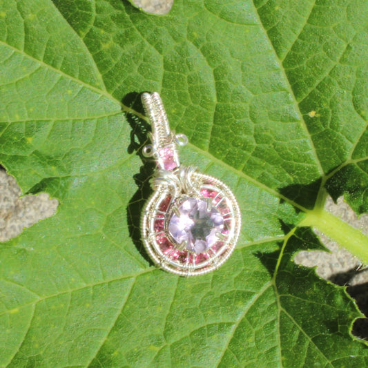 Amethyst Sterling Silver pendant with pink tourmaline accents on a green leaf background