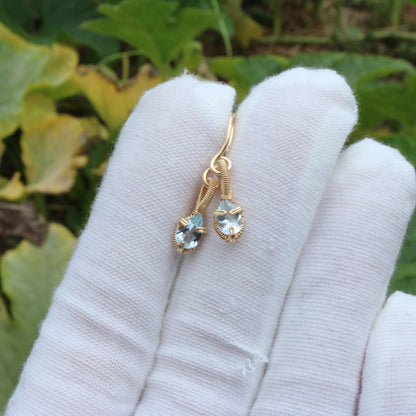 Aquamarine gold fill earrings displayed elegantly on a hand with a soft background