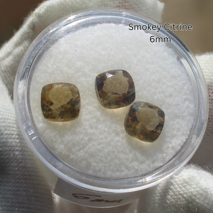 Three 6mm smokey citrine cushion gemstones in clear display for Made to order rings