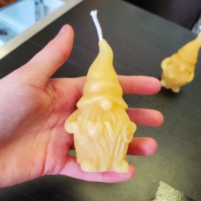 Beeswax gnome candle held in hand, featuring detailed design and natural color
