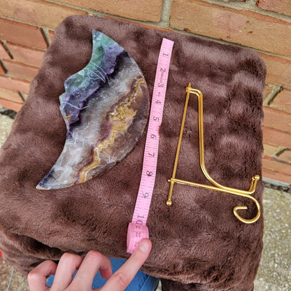 Big Rainbow Fluorite Moon on a plush surface with a measuring tape and a gold stand for display.