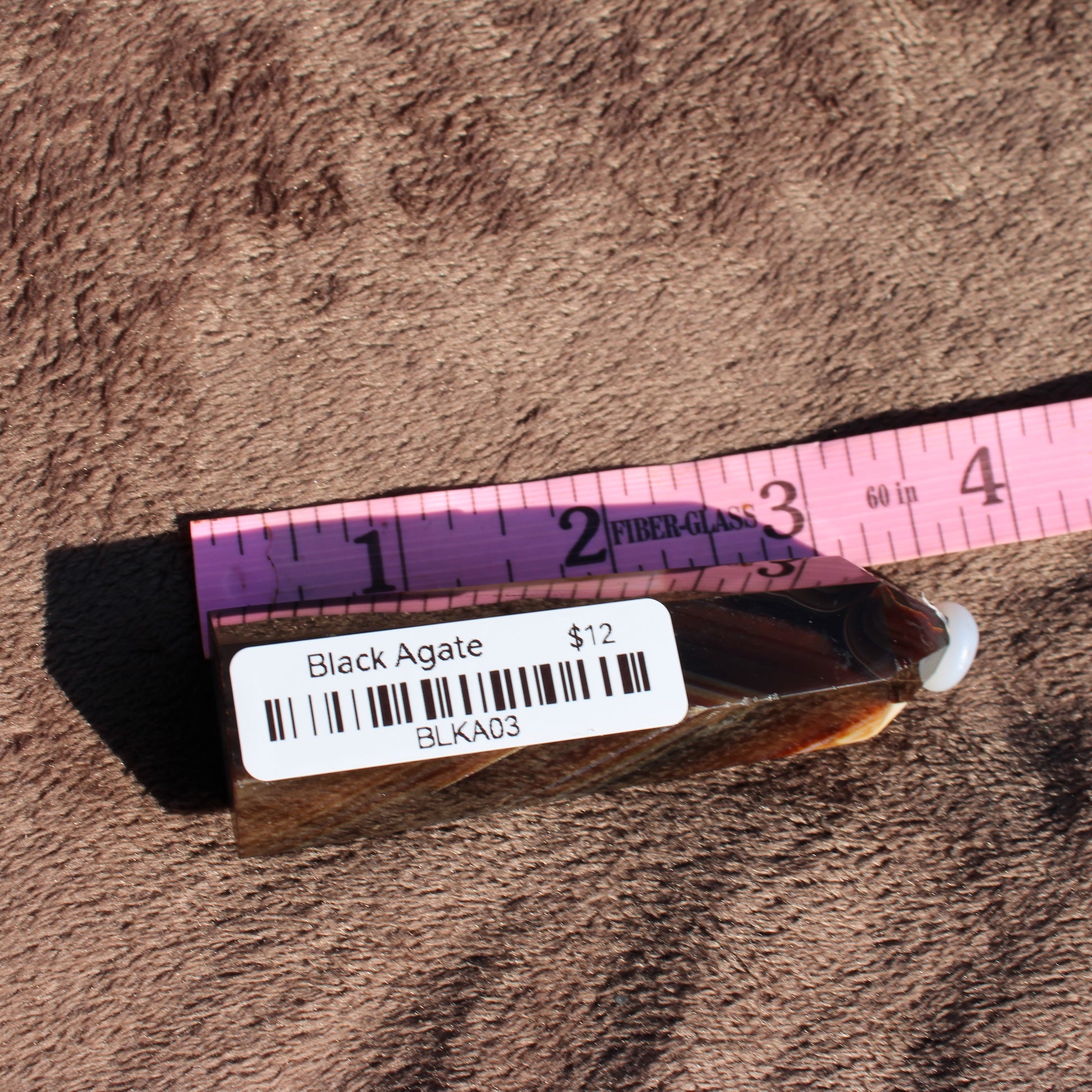 Black Agate Tower Collection showcasing a polished crystal with a price tag for decorative use