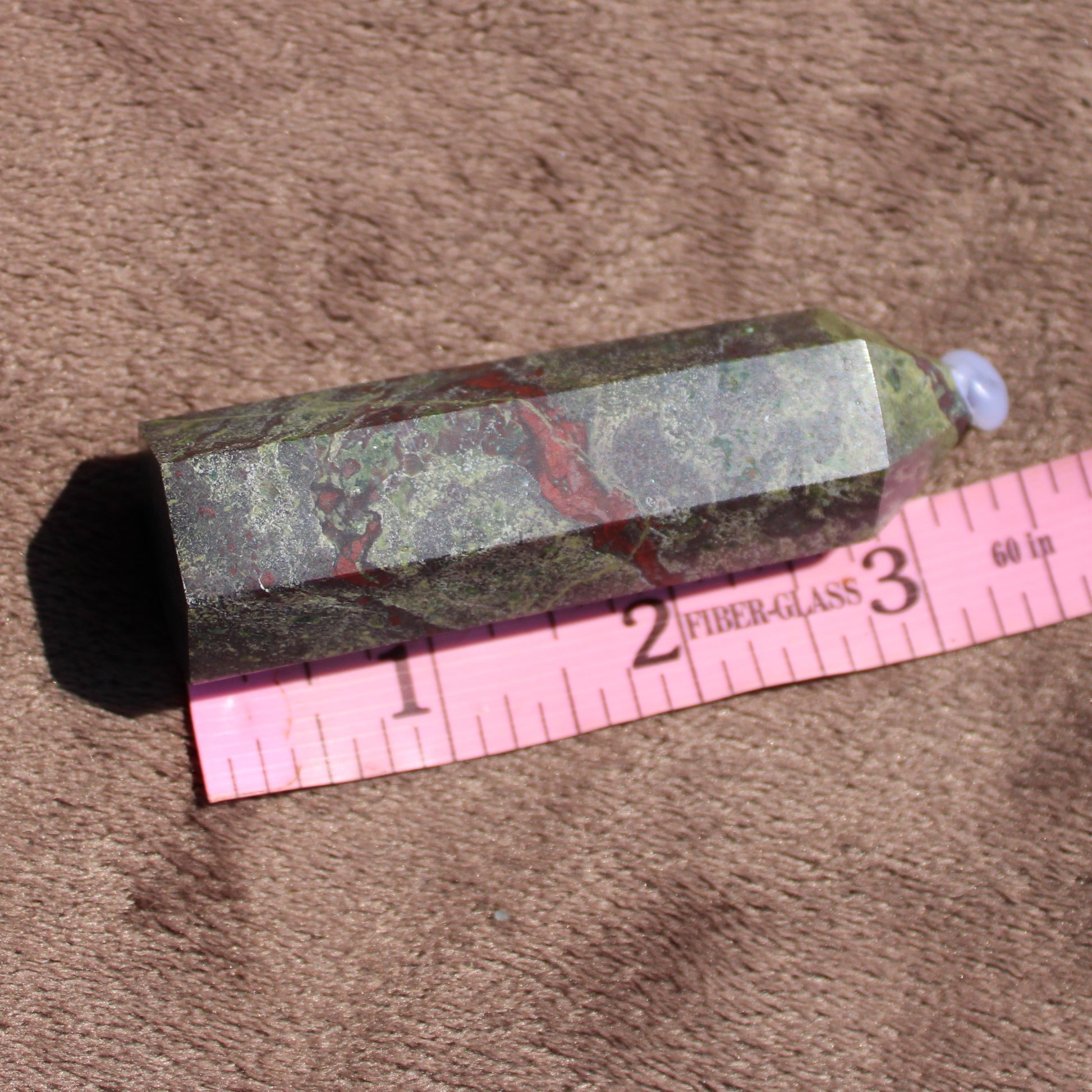 Bloodstone tower crystal with unique green patterns and red inclusions, measuring approximately 4 inches long