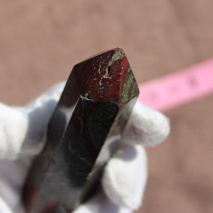 Bloodstone tower with rich red and green colors, held by a person wearing white gloves