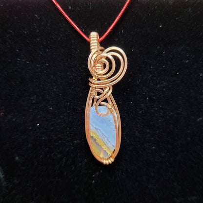 Gold Wire Wrapped Pendant with Blue Chalcedony Stone on a Red Necklace